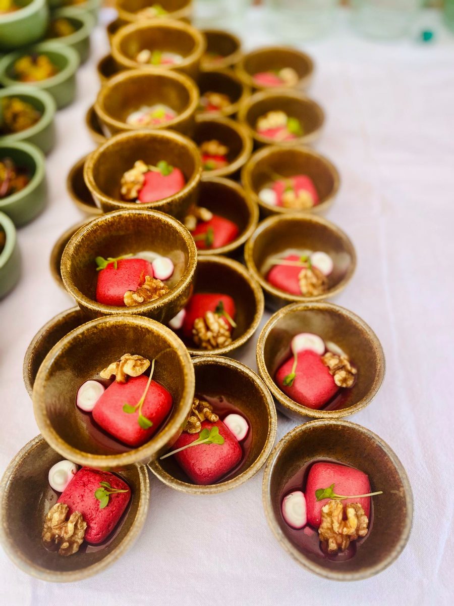 Reihe brauner Steingutschälchen mit Rote-Bete-Würfeln, Walnuss, Cremetupfen und Kresse